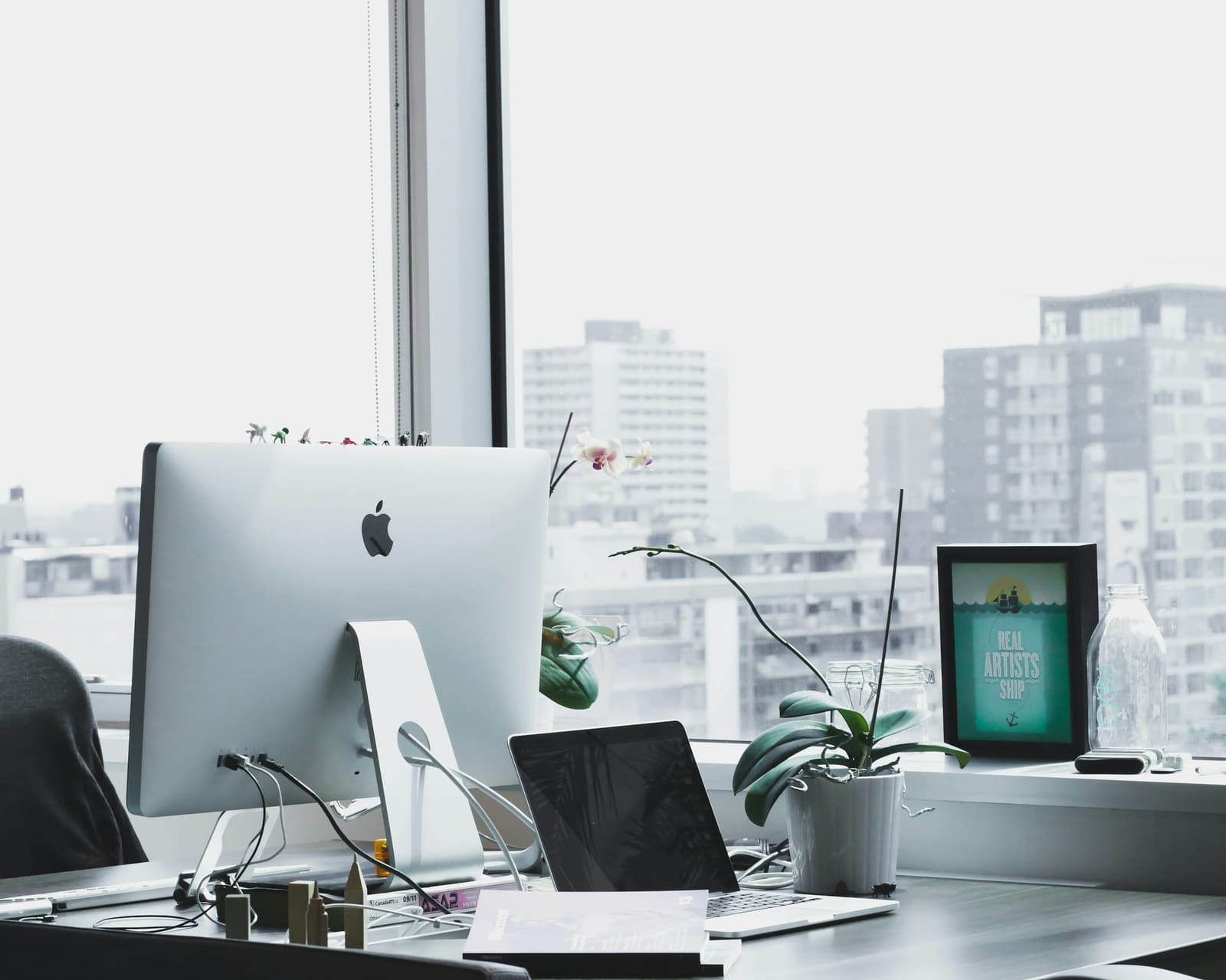 Bright modern office workspace with a desktop computer overlooking the city