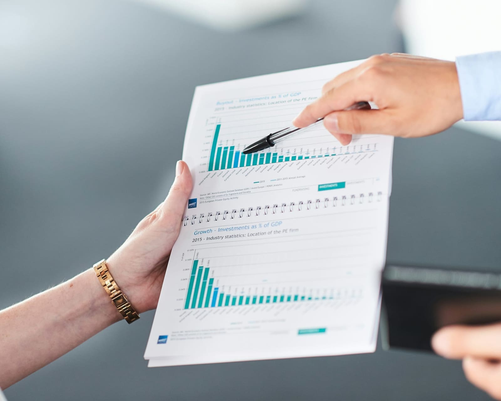 Accountant reviewing a financial report with charts alongside a client