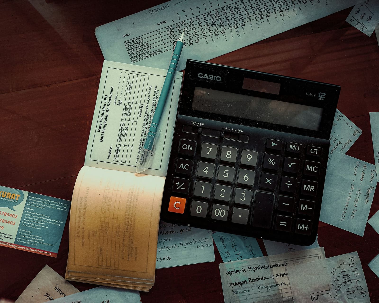 Calculator, receipts and a ledger ready for monthly bookkeeping