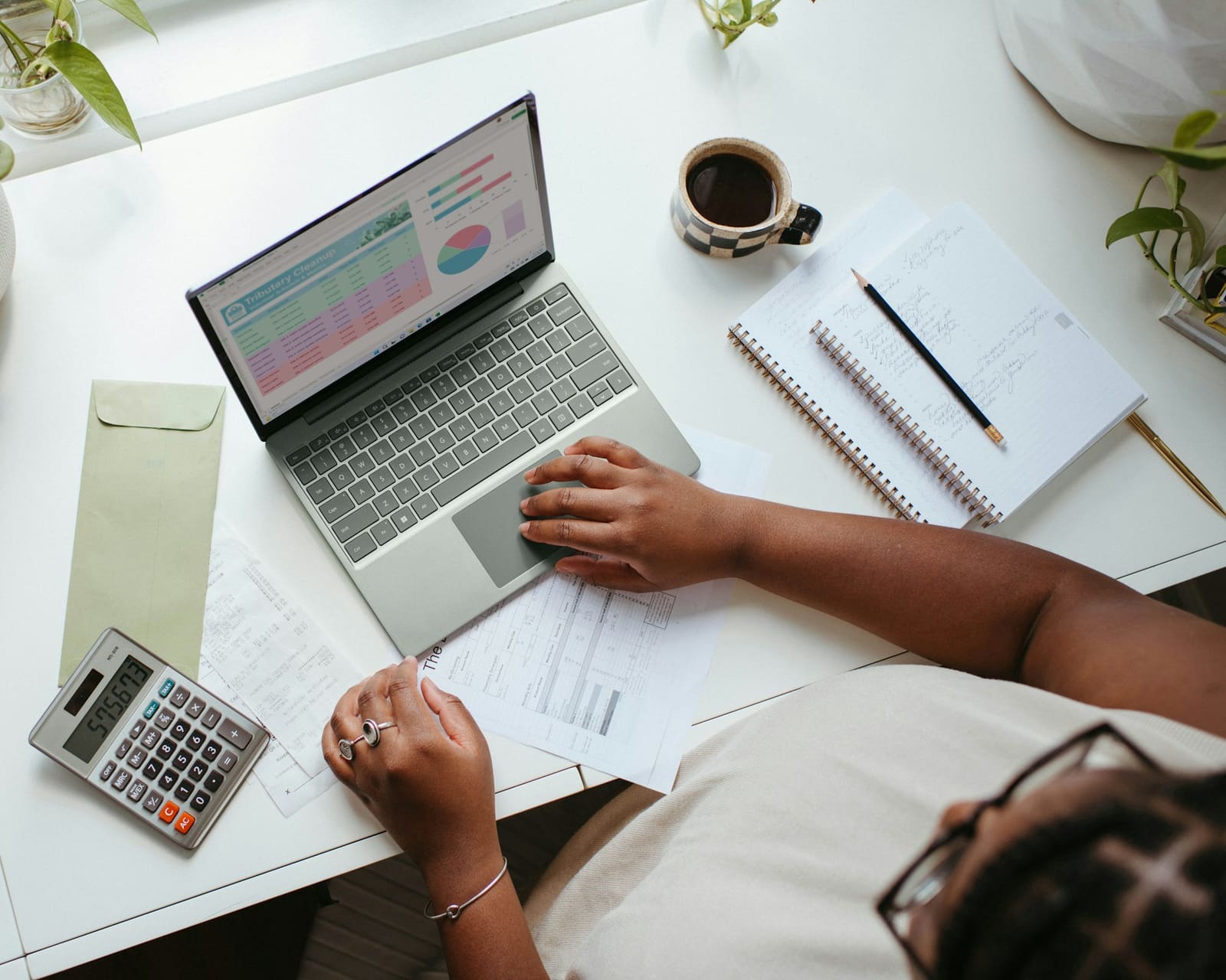 Accountant preparing a VAT return on a laptop with a calculator and documents