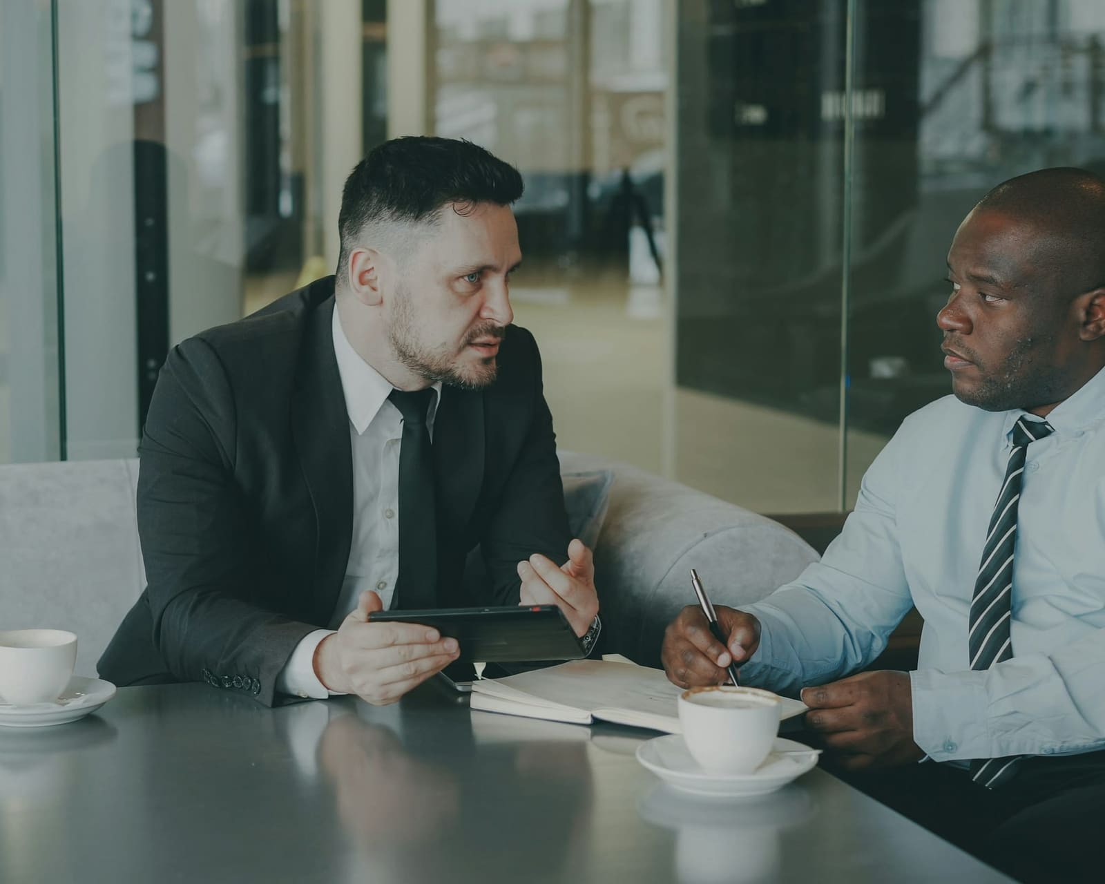 Accountant in conversation with a business client over coffee