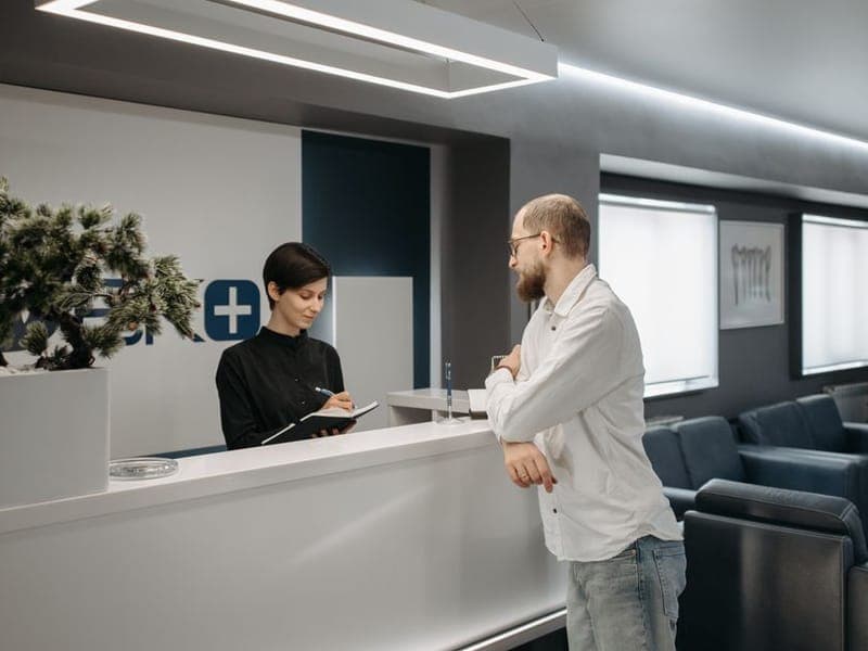 Reception desk where a client is greeted
