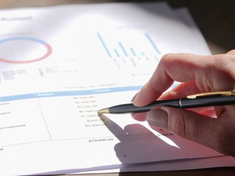 A financial report with charts being reviewed with a pen