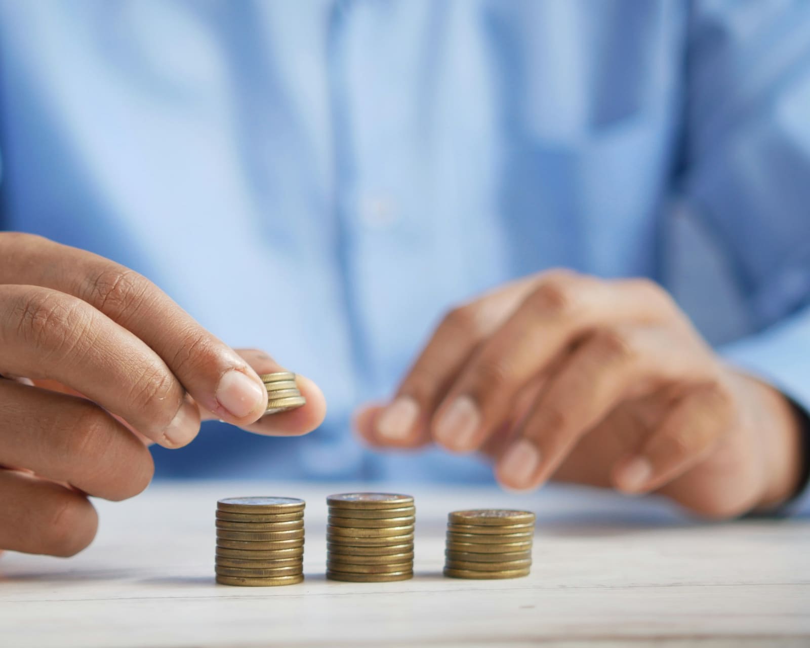 Business owner stacking coins while planning payroll costs